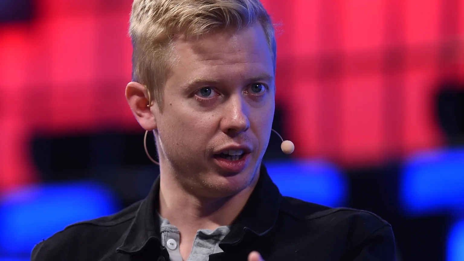 Reddit CEO'su Steve Huffman konuşurken; arka plan koyu, sahne ayrıntısı bastırılmış. Fotoğraf: Web Summit / CC BY 2.0, Wikimedia Commons