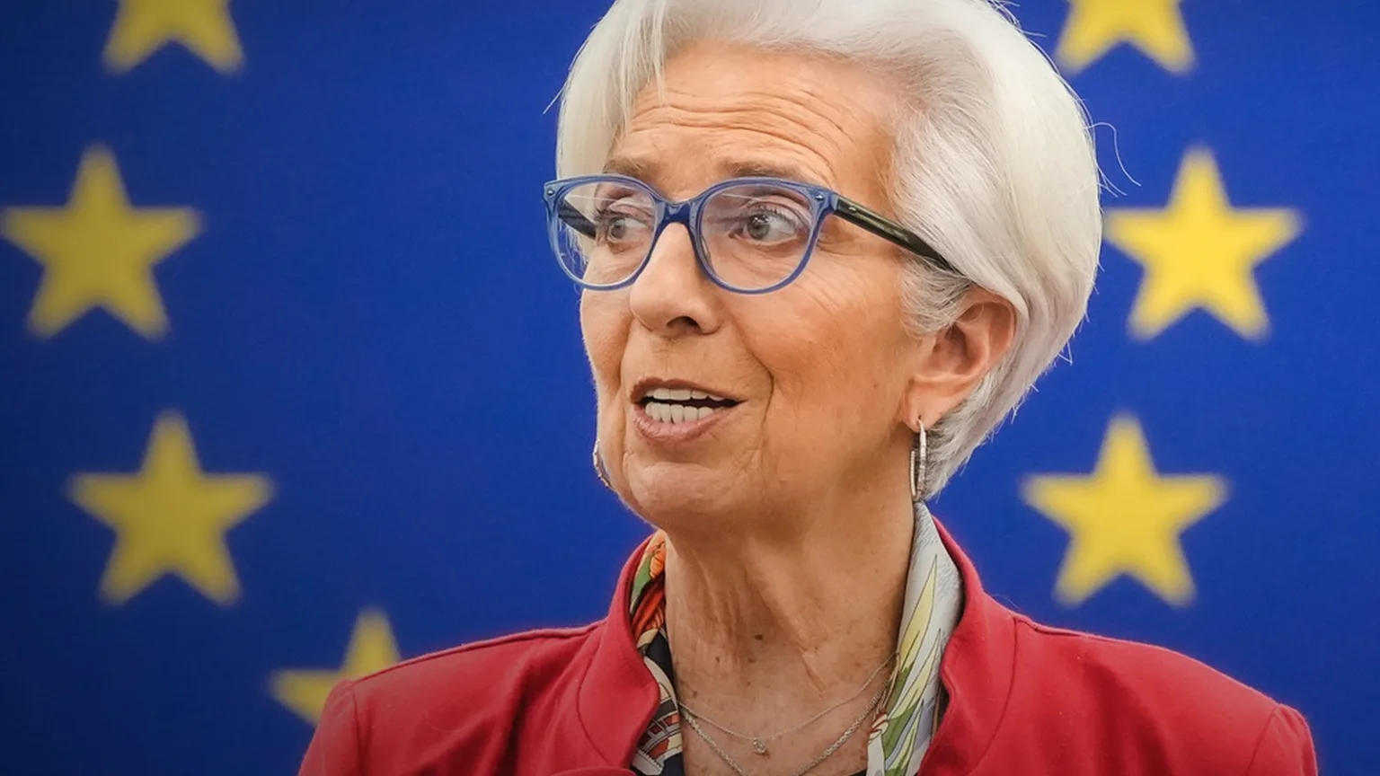 Christine Lagarde konuşma yapıyor, arkasında Avrupa Birliği bayrağı